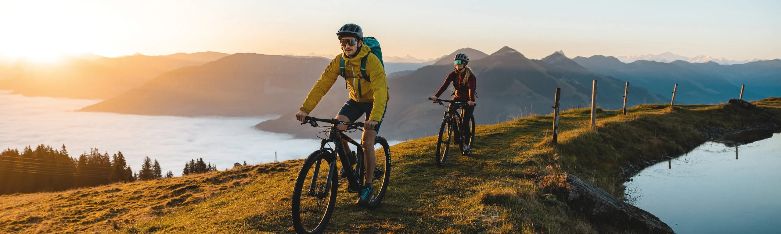 Radfahrer im Brixental während des Herbsts, umgeben von Bergen und Wasser