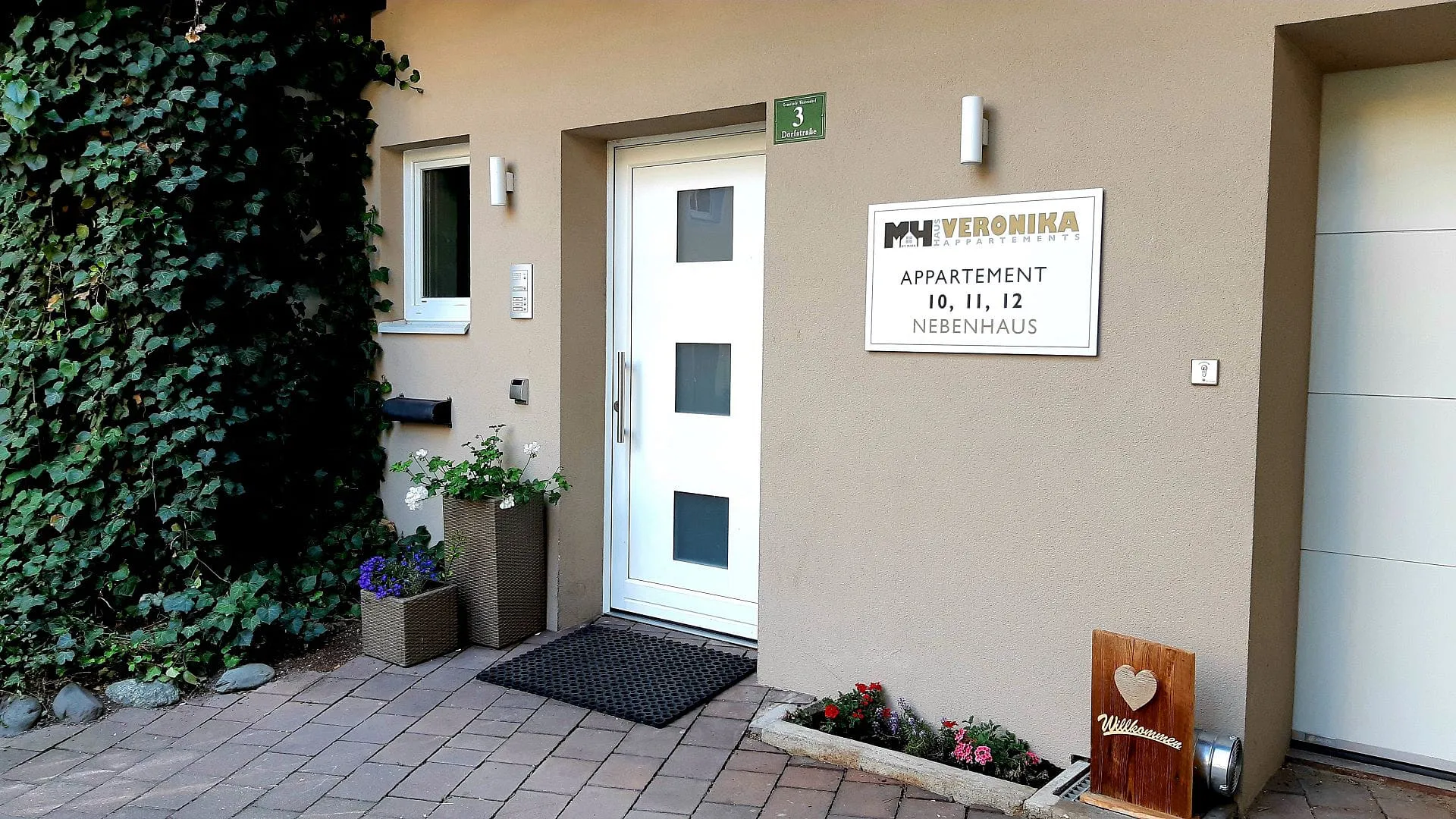 Eingang zum Appartement 10, 11, 12 mit Beschilderung und Pflanzen