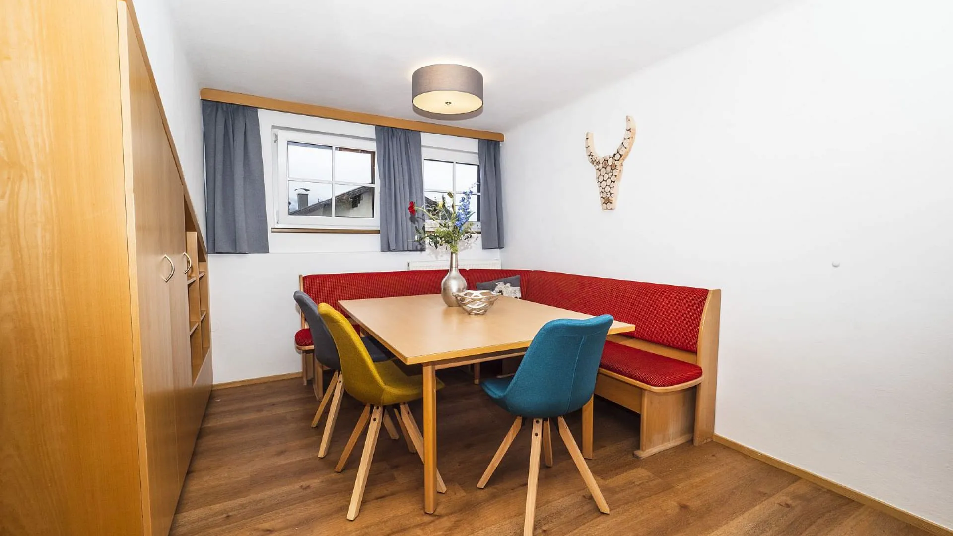 Kleine Esszimmer mit einem Tisch und bunten Stühlen
