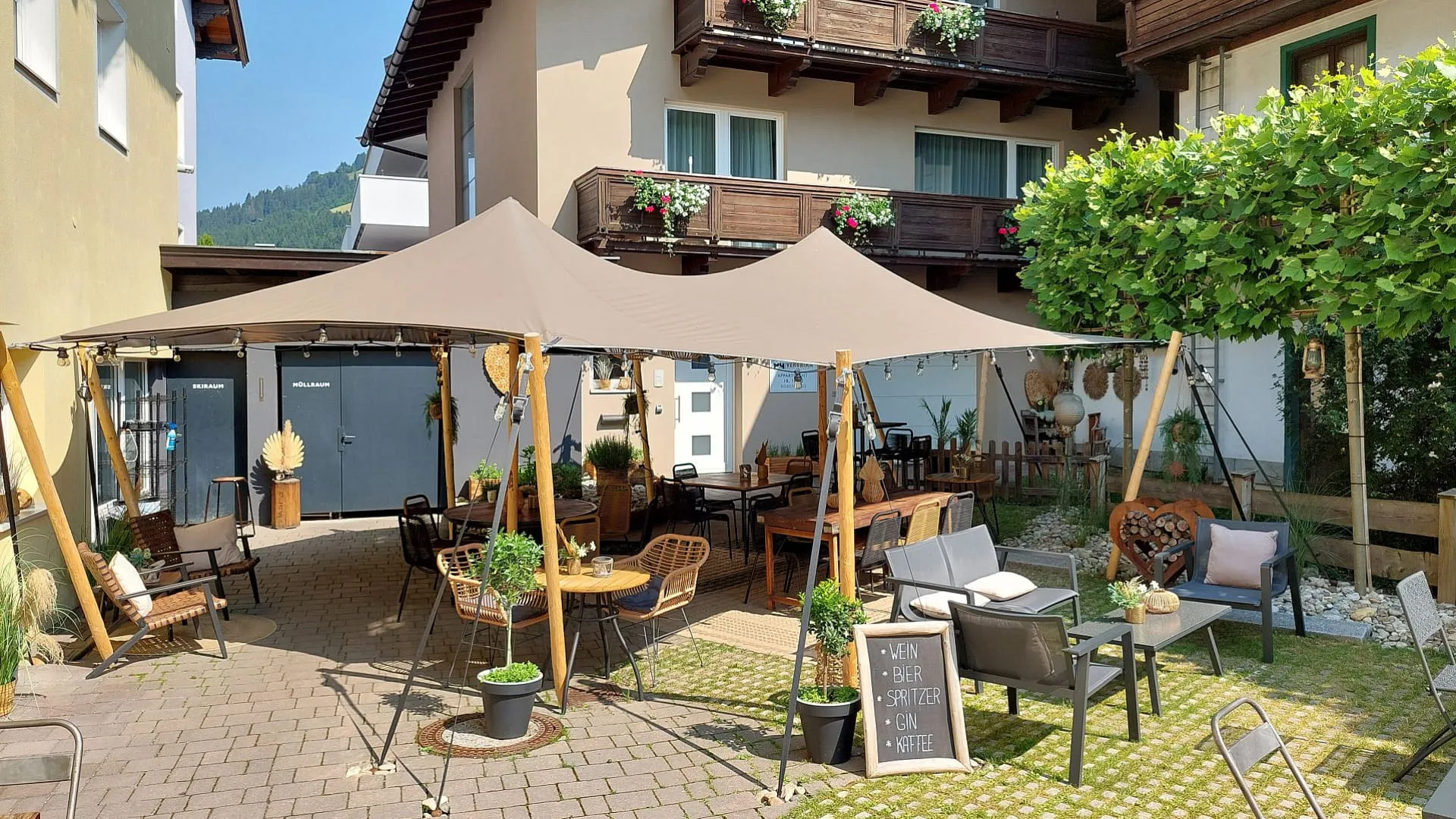 Ein schattiges Café-Außenbereich mit Stühlen und Tischen unter einem Zelt.