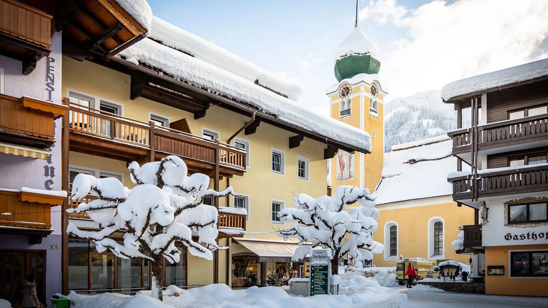 Schneebedeckte Straße mit bunten Gebäuden und einem Kirchturm
