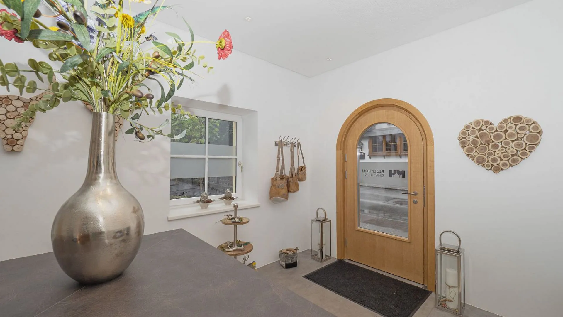 Innenansicht mit Vase, Holzstahltür und Dekorationen an der Wand