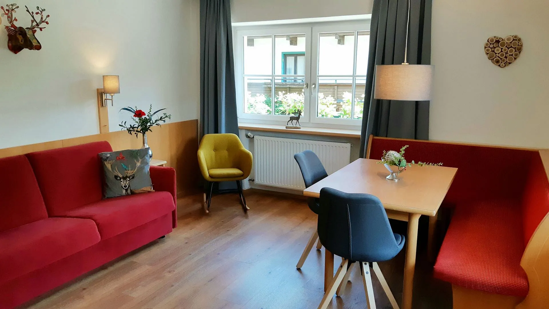 Wohnzimmer mit roten Sofas, Tisch und Fensterblick.