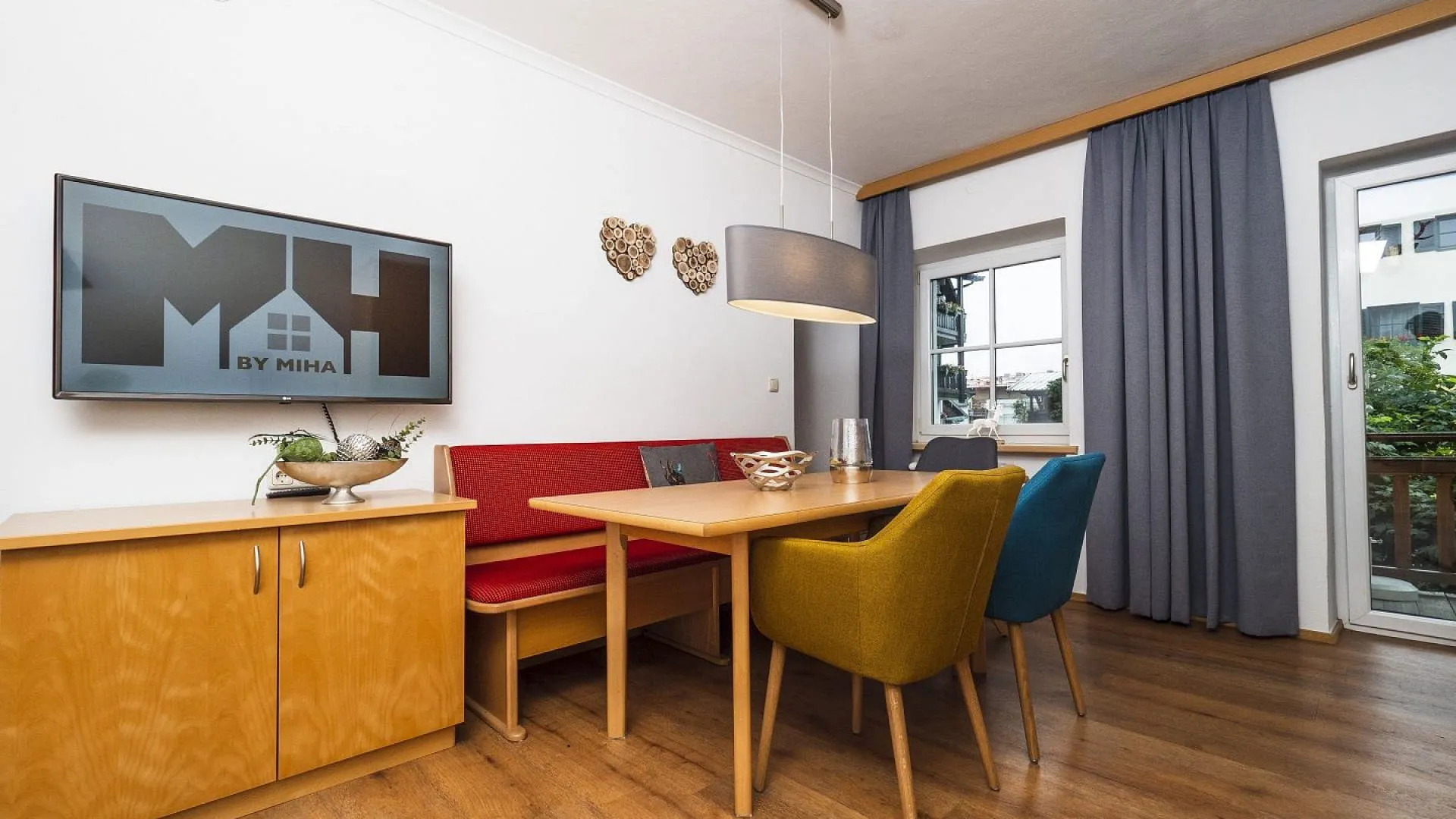 Modernes Interieur mit einem Essbereich, Fernseher und Zugang zum Balkon
