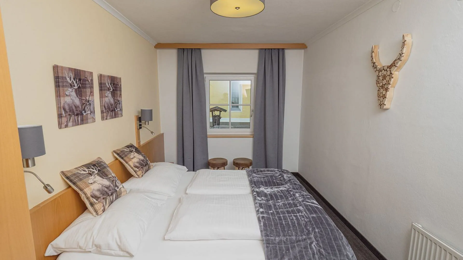 Helles Schlafzimmer mit Doppelbett, Bildern und einem Aussichtfenster