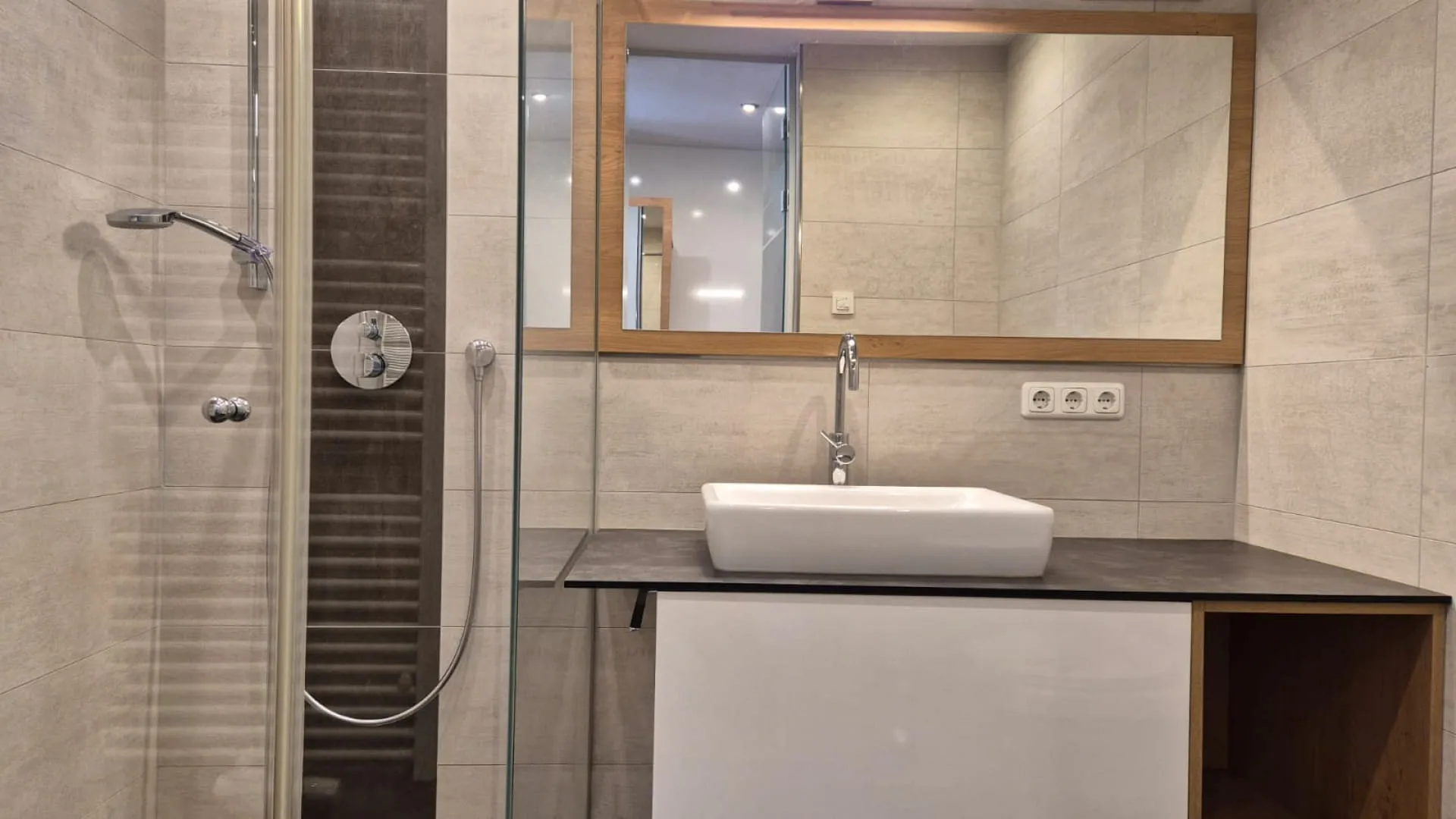 Modernes Badezimmer mit Dusche, Waschtisch und Spiegel